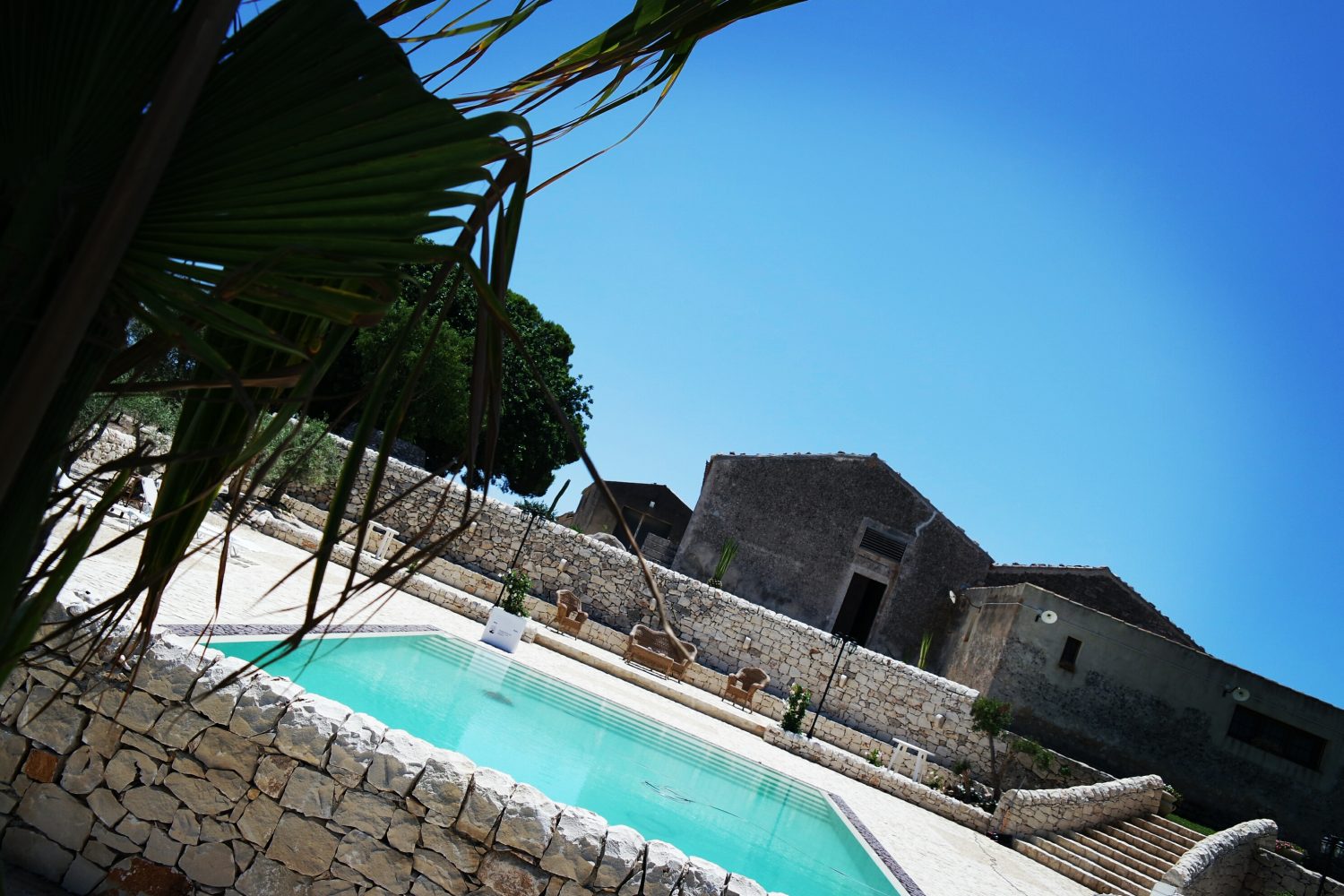 Il panorama, dietro la piscina si infrange nell'azzurro della Sicilia